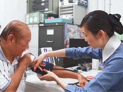 A public health nurse performing health screening for a member of the public