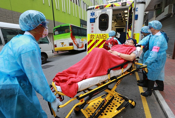 Ambulance officers of the Fire Services Department deliver a quarantined inmate to an ambulance.