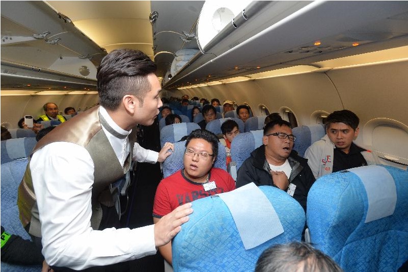 Under simulation, a passenger (second right) on the flight develops symptoms suspected of Ebola and a flight attendant approaches to follow up. Under simulation, a passenger (second right) on the flight develops symptoms suspected of Ebola and a flight attendant approaches to follow up.