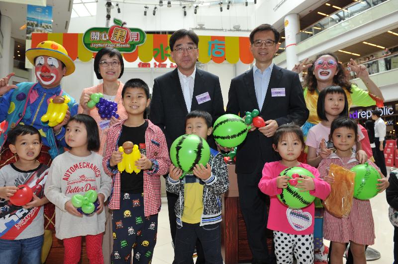 高永文（后排中）、陈汉仪医生（后排左二）及梁挺雄医生（后排右二）在「开心『果』月」水果店前与一班小朋友合照。
